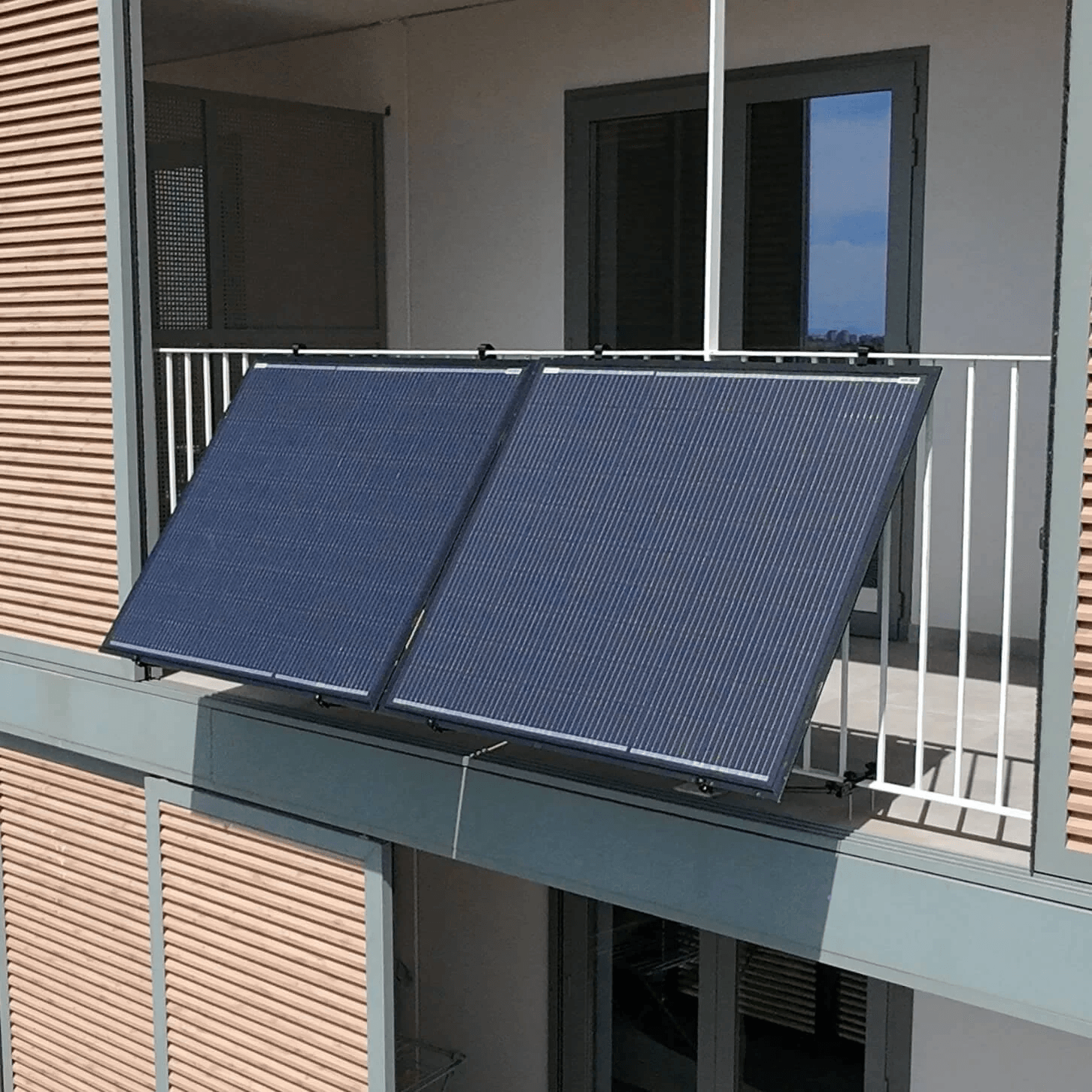 Over-the-rail balcony solar installation on modern apartment